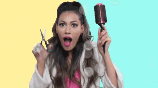 a woman is holding a brush and scissors in her hand .