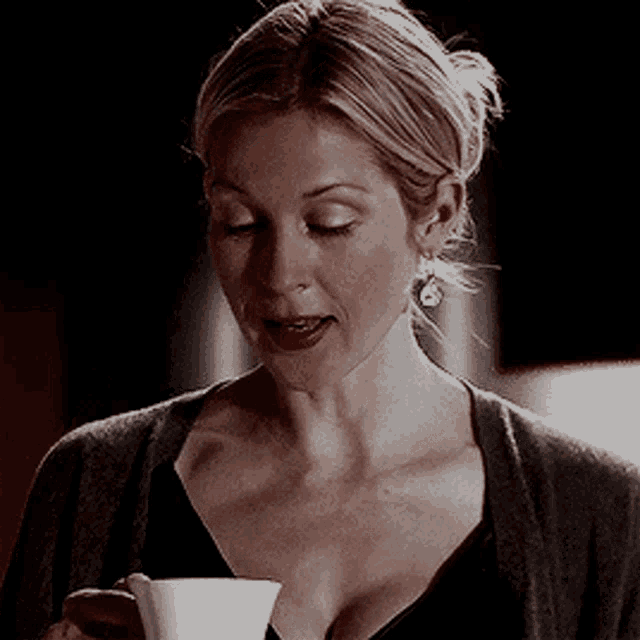 a woman holding a cup of coffee in her hand