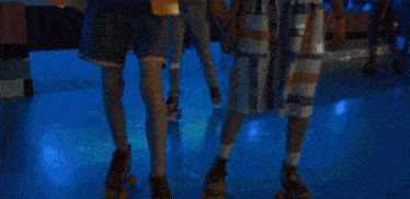 a group of people are rollerblading together in a rink .