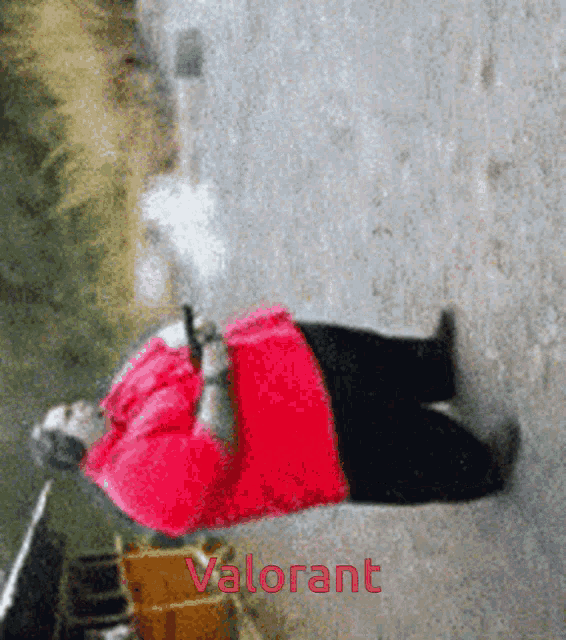 a woman in a red shirt is laying on the ground with the word valorant on the bottom right