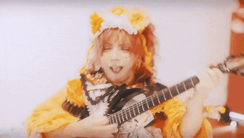 a person playing a guitar with a mask on their face