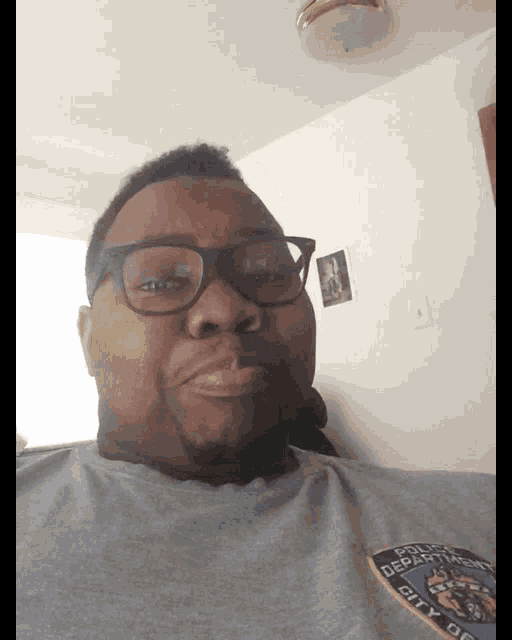 a man wearing glasses and a shirt that says police department on it