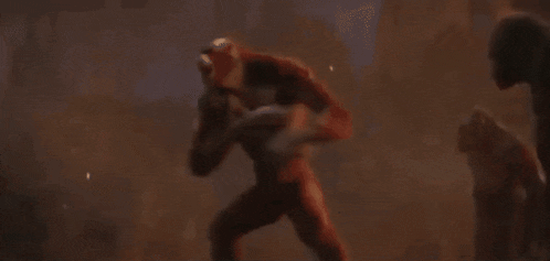 a man in a red costume is standing in a field with his arms outstretched and a belt around his waist .