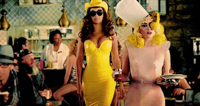 a woman in a yellow dress is standing next to a woman in a white dress