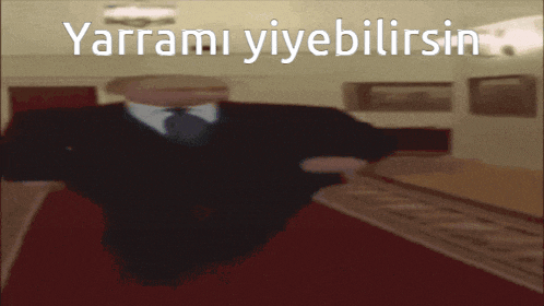 a man in a suit and tie is walking down a hallway with the words yarrami yiyebilirsin written above him