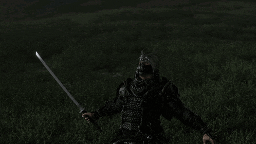 a man in armor is laying in the grass with a sword