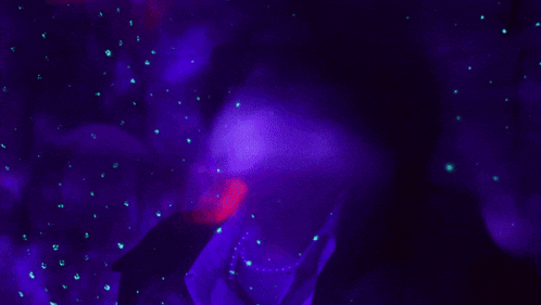 a person in a dark room with purple lights