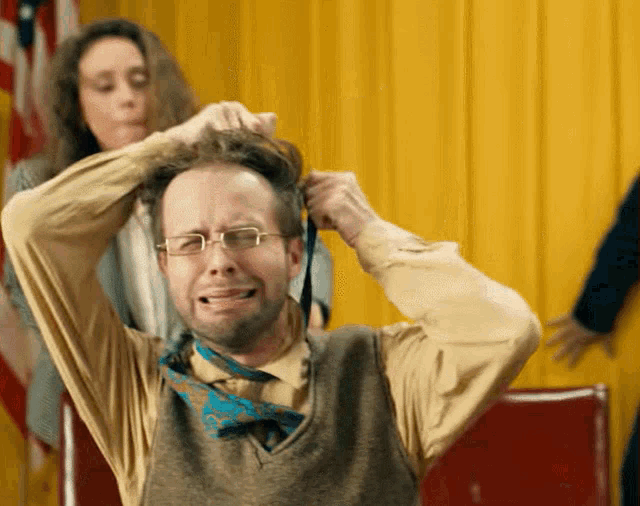 a woman is tying a man 's tie and making him laugh