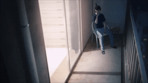 a man is sitting on a chair on a balcony