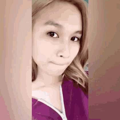 a woman with blonde hair is wearing a purple shirt with a white zipper