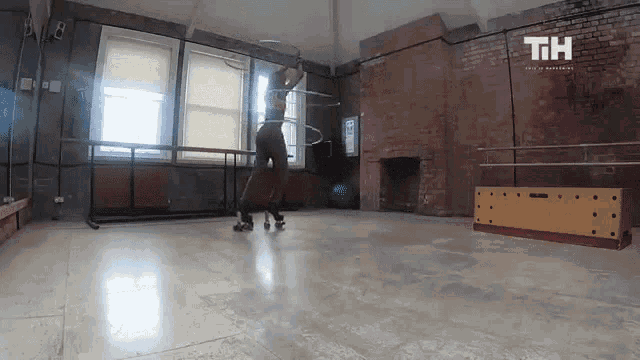 a woman is spinning a hula hoop in a room with the letters tih on the bottom