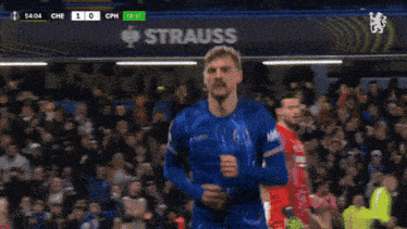 a soccer game is being played in front of a strauss banner