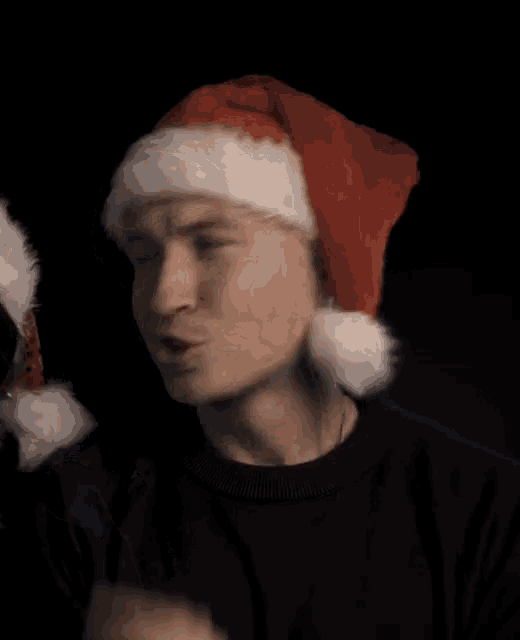 a man wearing a santa hat and a black sweater