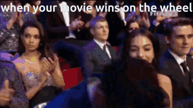 a group of people are sitting in a theatre watching a movie .