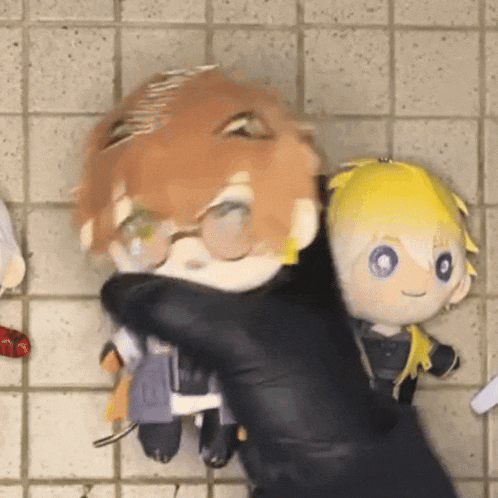 a person is holding two stuffed animals in their hands