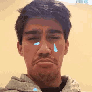 a man with a tear coming out of his eye is making a sad face .