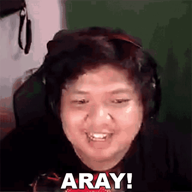 a man wearing headphones is making a funny face and saying aray .