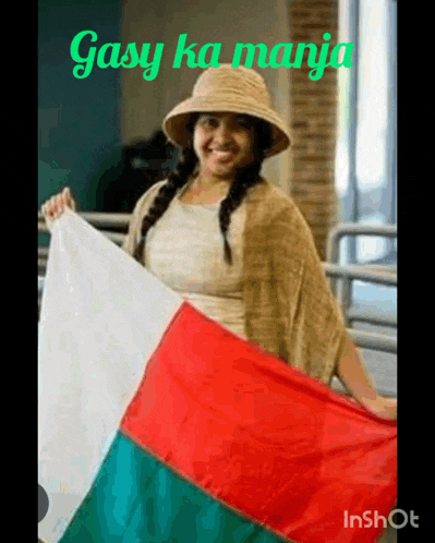 a woman in a hat is holding a flag with the words gasy ka manja written above her