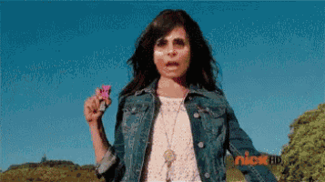 a girl in a denim jacket is holding a pink flower in front of a screen that says nickelodeon