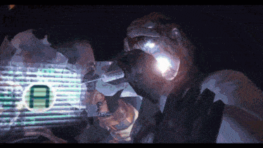 a man is holding a syringe in front of a screen with the letter a