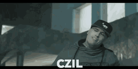 a man wearing a hat and a hoodie is smiling .