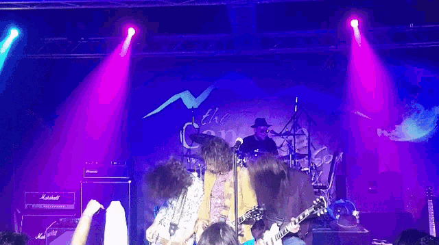 a group of people playing guitars on a stage with a marshall amp in the background