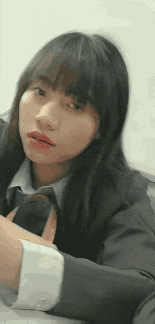 a woman in a suit and tie is looking at the camera