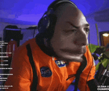 a man wearing a nasa shirt and headphones looks at the camera
