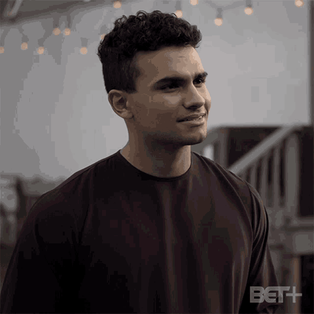 a man wearing a purple shirt with bet + written on the bottom