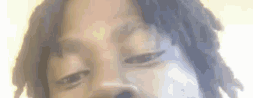 a close up of a man 's face with his eyes closed and dreadlocks .
