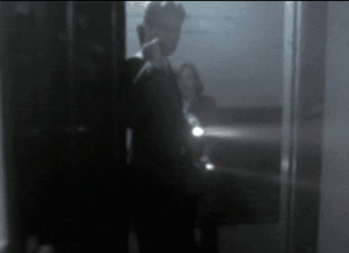 a blurry picture of a man talking on a cell phone in a dark room