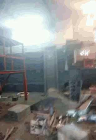 a room with smoke coming out of the ceiling and a few boxes on the floor