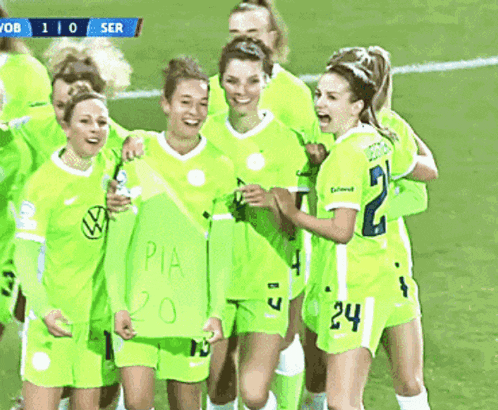 a group of female soccer players are celebrating a goal with a sign that says pia 20