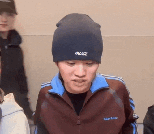 a man wearing a palace beanie and a palace jacket