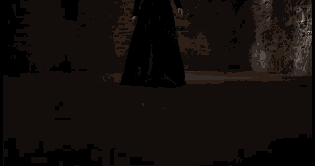 a woman in a black coat is standing in a dark room looking at the camera .