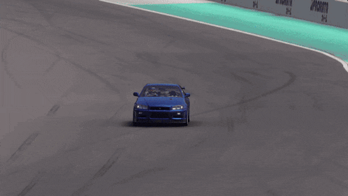 a blue car is driving down a race track with a sign that says ' priority ' on it