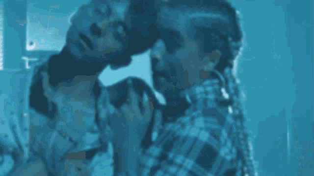 a man and a woman are sitting next to each other in a room in a dark room .