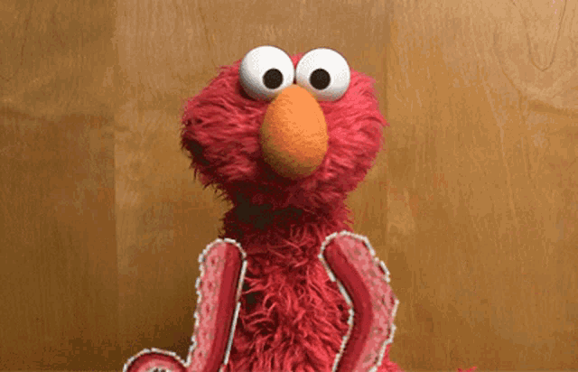 elmo the sesame street character is sitting on a table