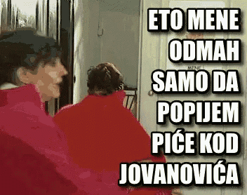 a woman in a red jacket is talking to another woman in a red jacket in front of a refrigerator .