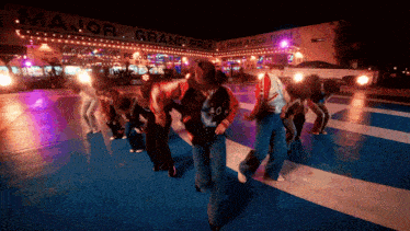 a group of people are dancing in front of a building that says major grand prix