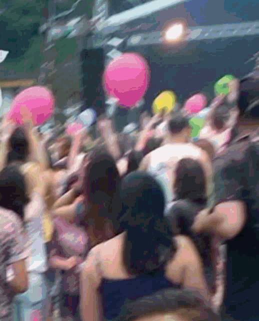 a crowd of people holding balloons in their hands