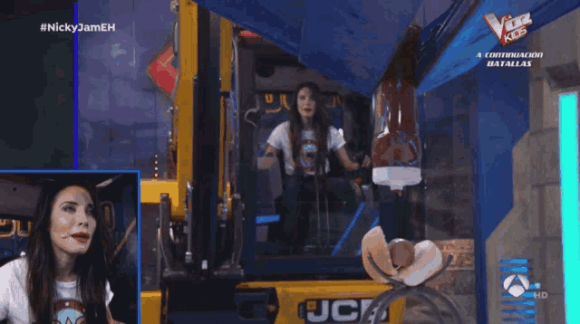 a woman is sitting in a yellow jcb truck on a tv screen