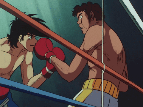 two men are boxing in a ring with one wearing red gloves