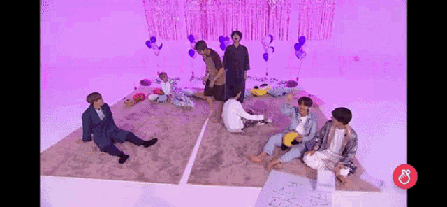 a group of people are sitting on a carpet in a room with purple walls .