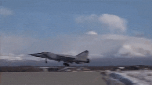 a fighter jet is taking off from a runway in the snow .