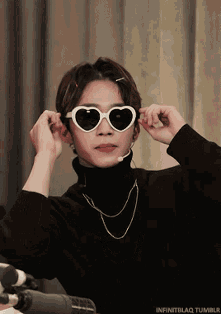 a man wearing heart shaped sunglasses and a black turtleneck sweater