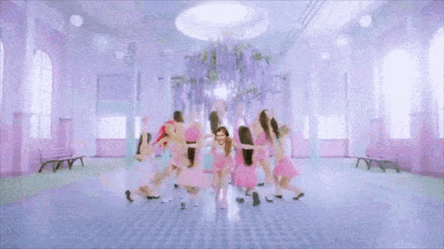 a group of women are dancing in a room and one of them has a face painted on her face