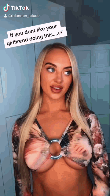 a woman is wearing a crop top with a ring around her breast and a caption that says tiktok