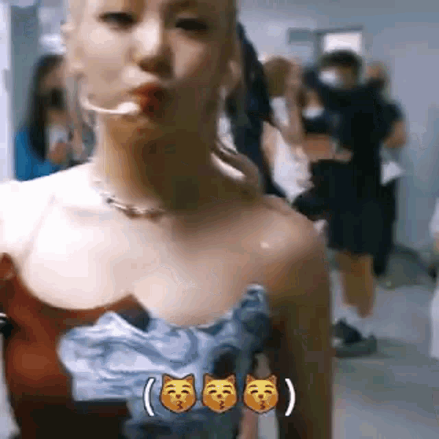 a woman in a dress is blowing a kiss while standing in a hallway .