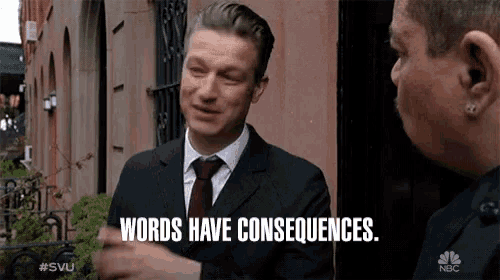 a man in a suit and tie is talking to another man and says words have consequences